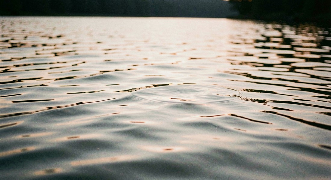 Evening ripples across a lake surface with low sun