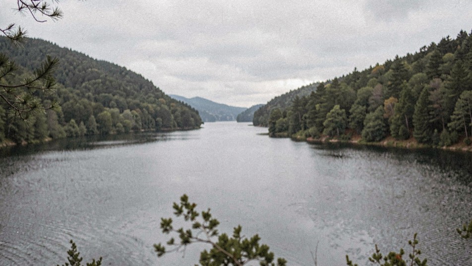 Long lake framed by wooded ridgelines under an overcast sky