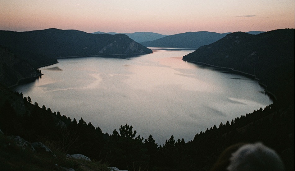 Lake basin ringed by ridge silhouettes at dusk